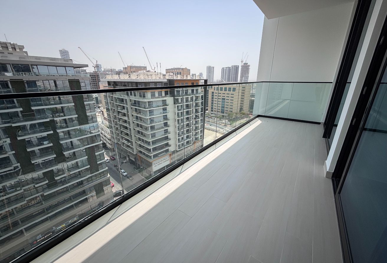 The open-plan kitchen comes fully equipped with built-in appliances including an oven