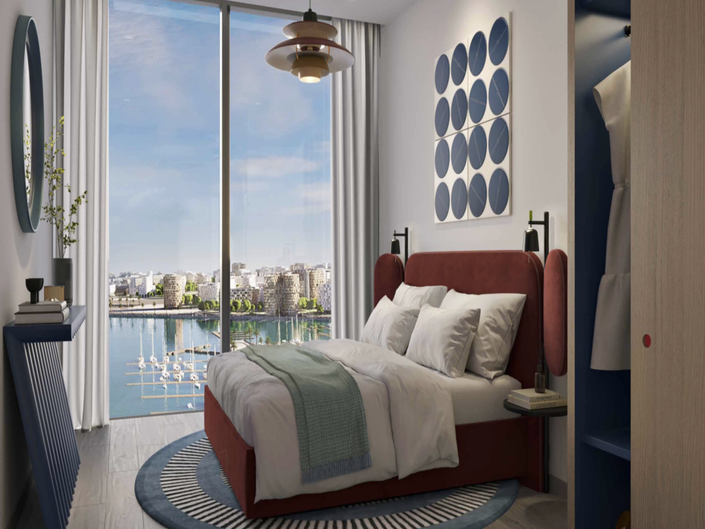 The 615 sq ft layout has an open kitchen and living area opening onto a private balcony overlooking the water. The bedroom comes with a built-in wardrobe